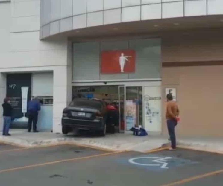 Se mete a farmacia con todo y auto