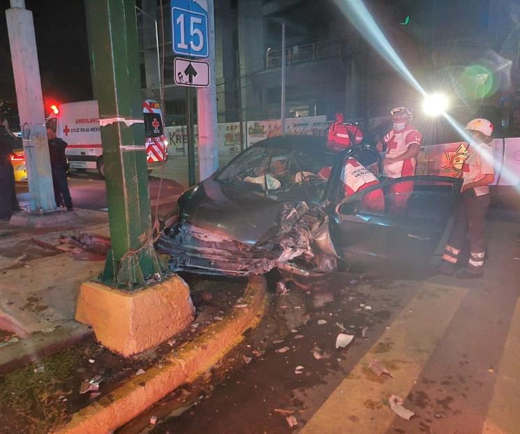Se estrella auto contra semáforo, hay dos lesionados