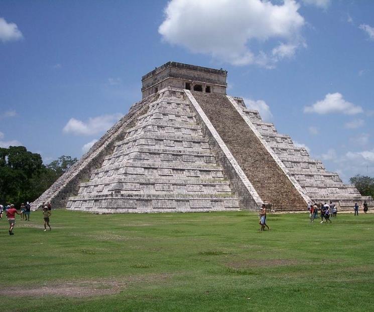 Turista sube a pirámide de Chichén Itzá Turista sube a pirámide de Chichén Itzá