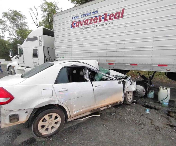 Termina auto debajo de tráiler