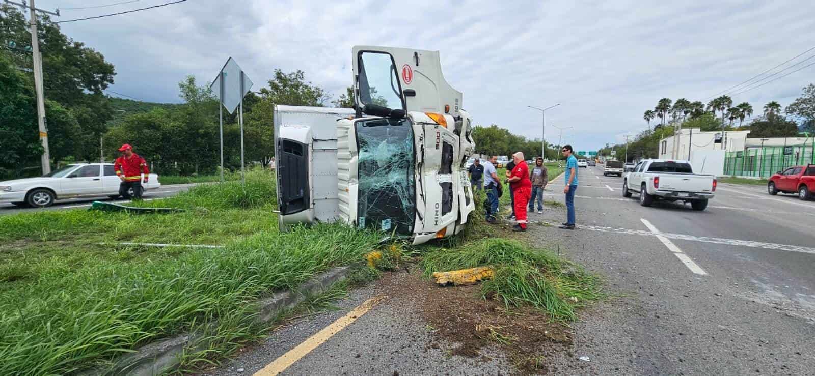 Un camión de carga se estrelló contra un árbol y señalamiento para luego terminar volcado, ayer en la Carretera Nacional, municipio de Santiago.