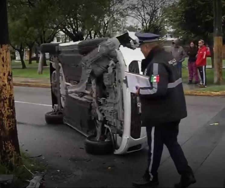 Vuelca en su auto tras estrellarse contra poste