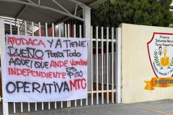 Aparece manta con amenazas en puerta de escuela