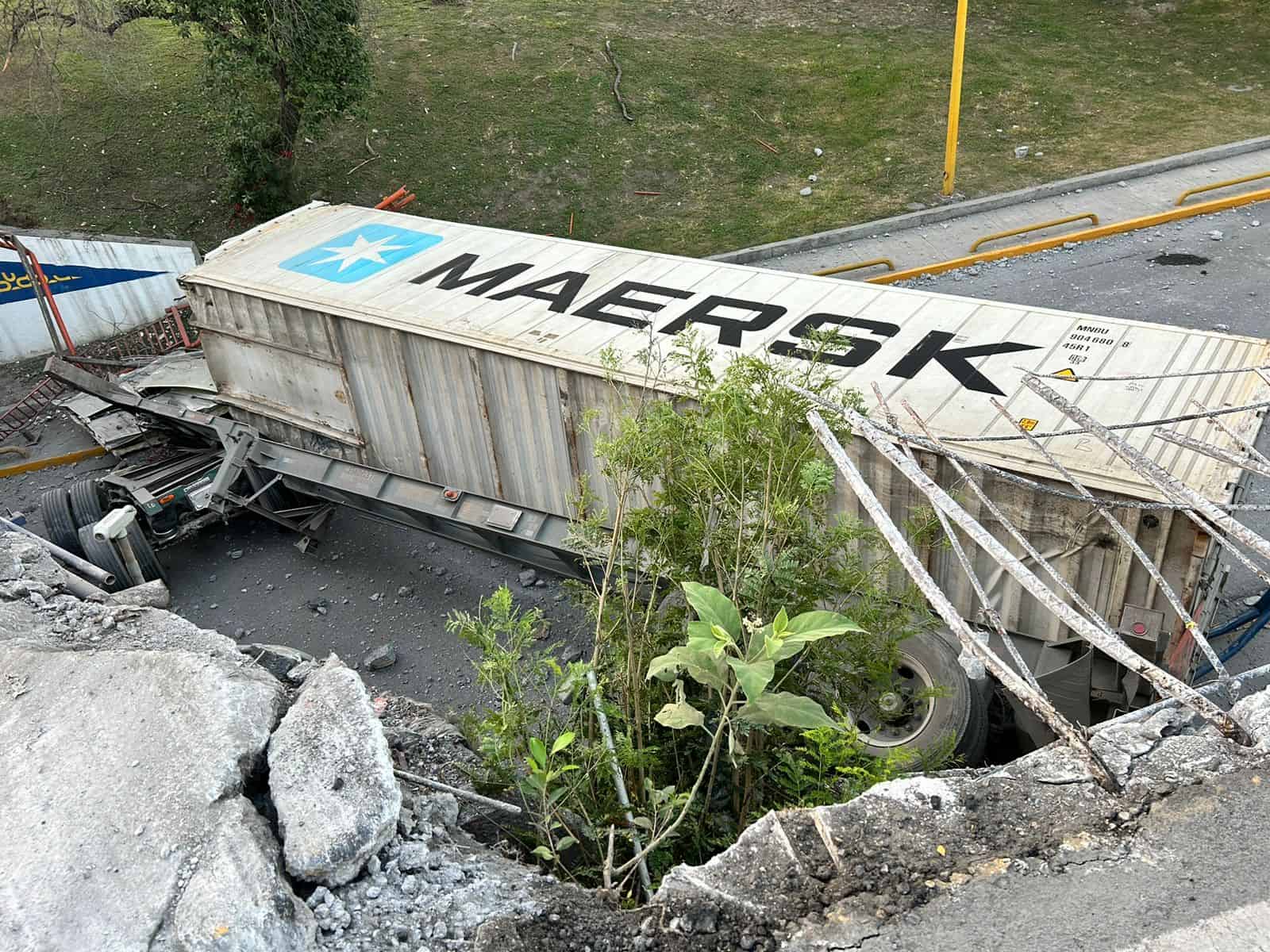 Un tráiler con doble caja volcó ayer en la Avenida Fidel Velázquez frente a Ciudad Universitaria, donde uno de sus contenedores cayó de un puente.