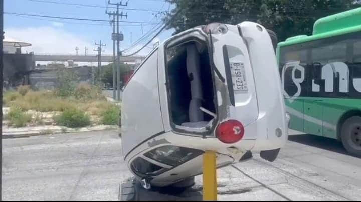 Un vehículo quedó volcado sobre un poste de protección luego de chocar contra un transporte urbano, ayer en el centro de Monterrey.