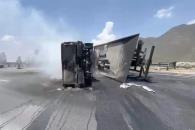 Arden grúa y camioneta tras volcadura